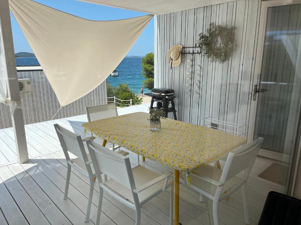 a table and chairs on a deck with the ocean at BUQEZ ECO RESORT - Beach Villas 2 and 8 - Seaview, new wifi! in Drage