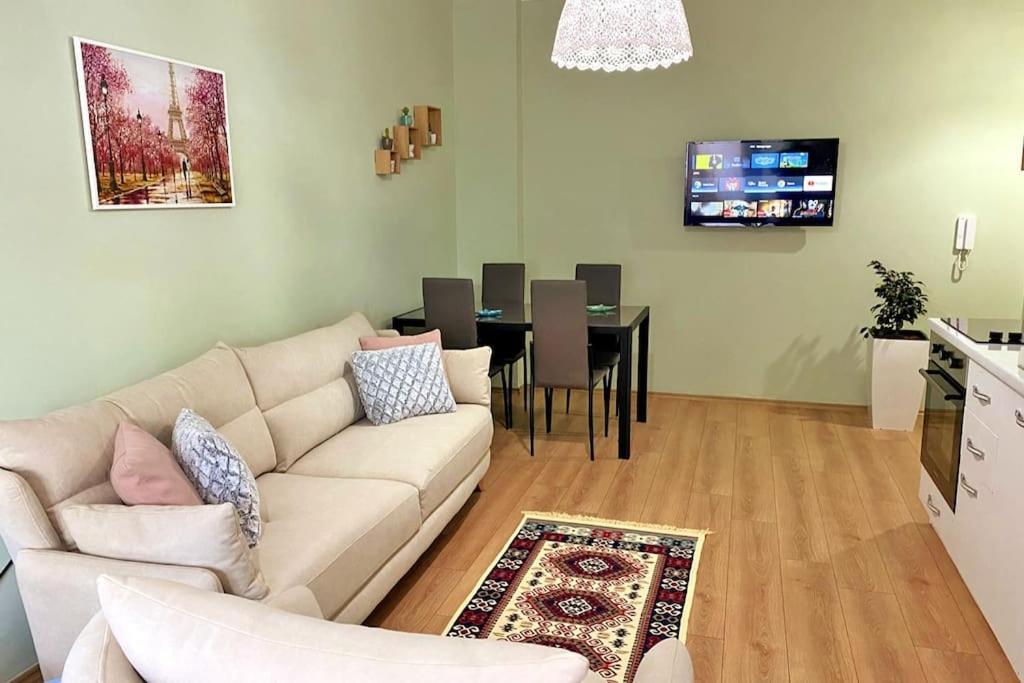 ein Wohnzimmer mit einem Sofa und einem Esszimmer in der Unterkunft The Ionian Comfort Apartment- Beachfront Lungomare Promenade in Vlorë