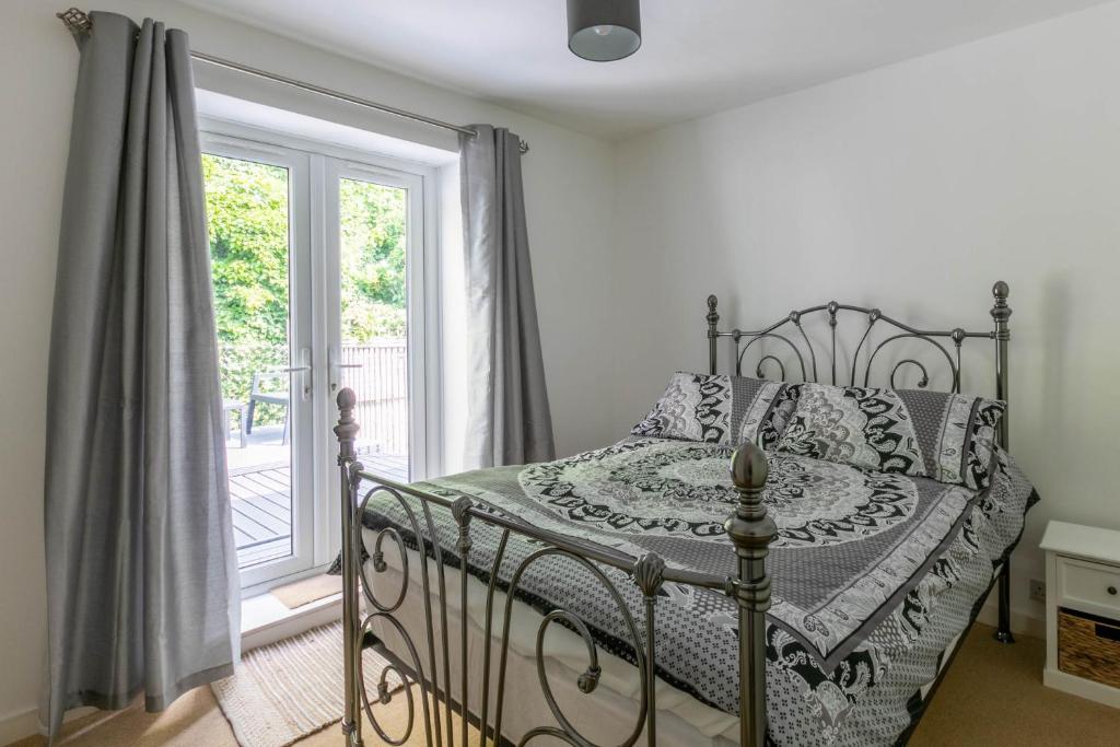 1 Schlafzimmer mit einem Bett und einem Balkon mit einem Fenster in der Unterkunft Stylish 2BD Family Hideaway in Dover in Dover