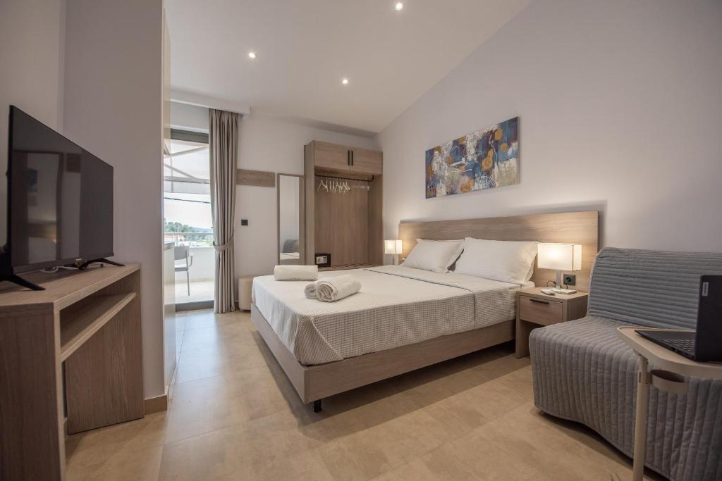 a bedroom with a bed and a tv and a couch at Casa de Lapel Kallithea in Kallithea Halkidikis