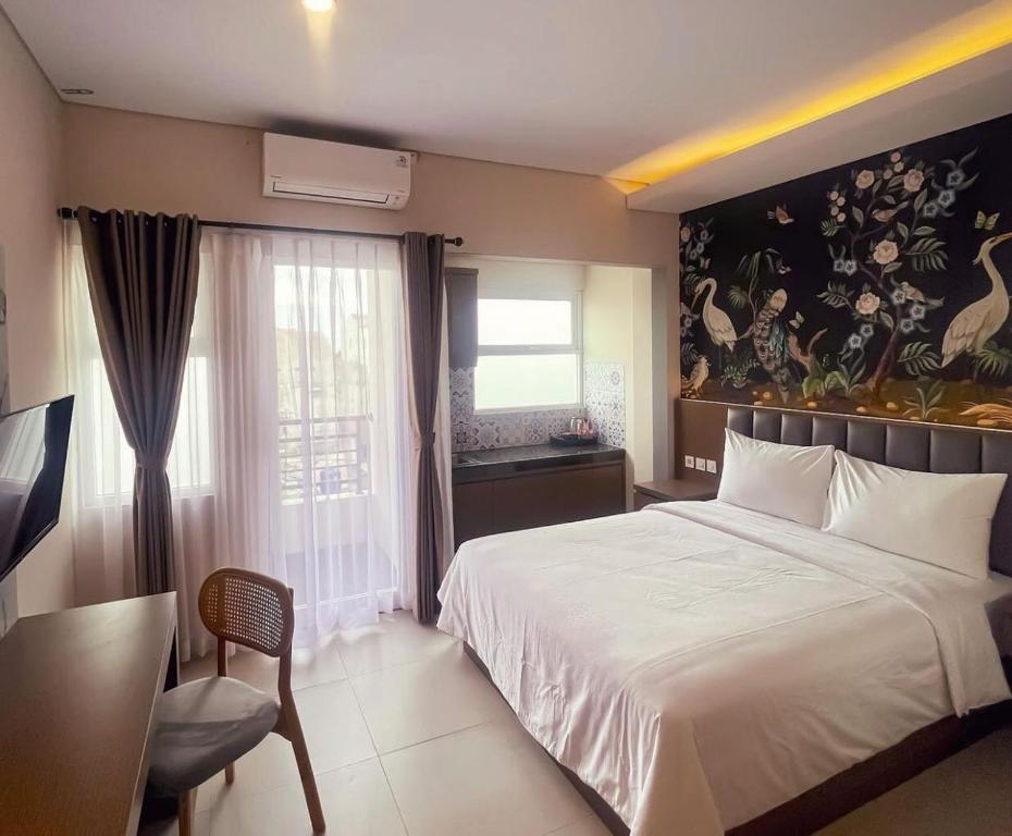 - une chambre avec un grand lit blanc et une fenêtre dans l'établissement AJ BOUTIQUE HOTEL, à Yogyakarta
