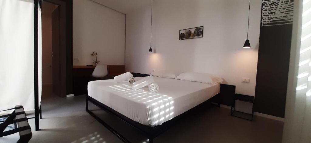 sypialnia z łóżkiem z białą pościelą i poduszkami w obiekcie Patio 101 "Exclusive" w mieście San Vito lo Capo
