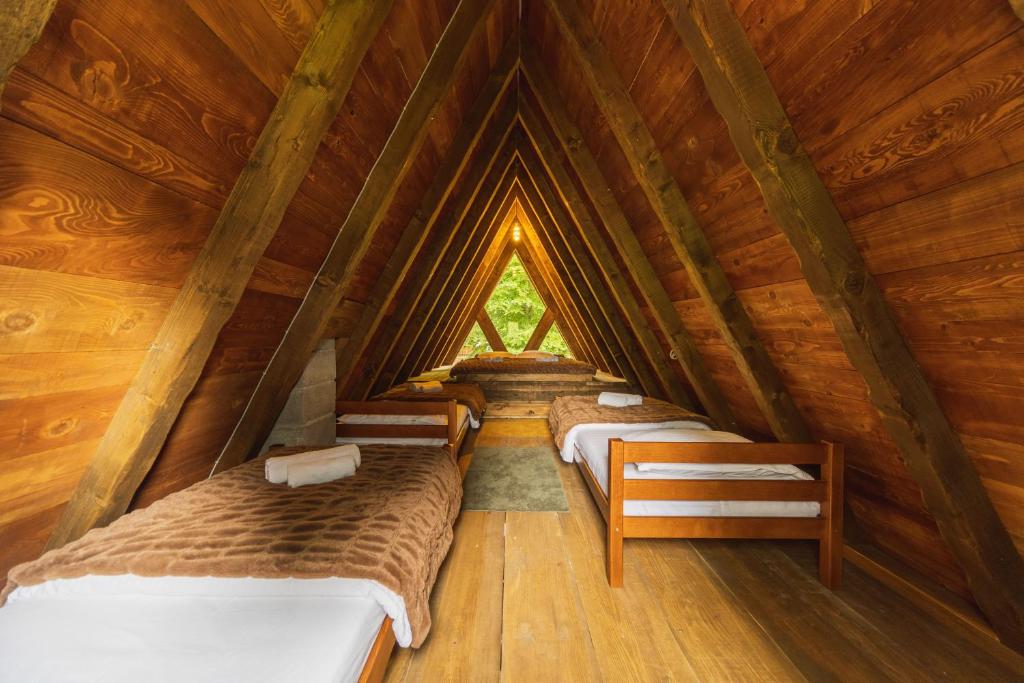 a room with three beds in a wooden attic at Woodland Brezna in Pluzine