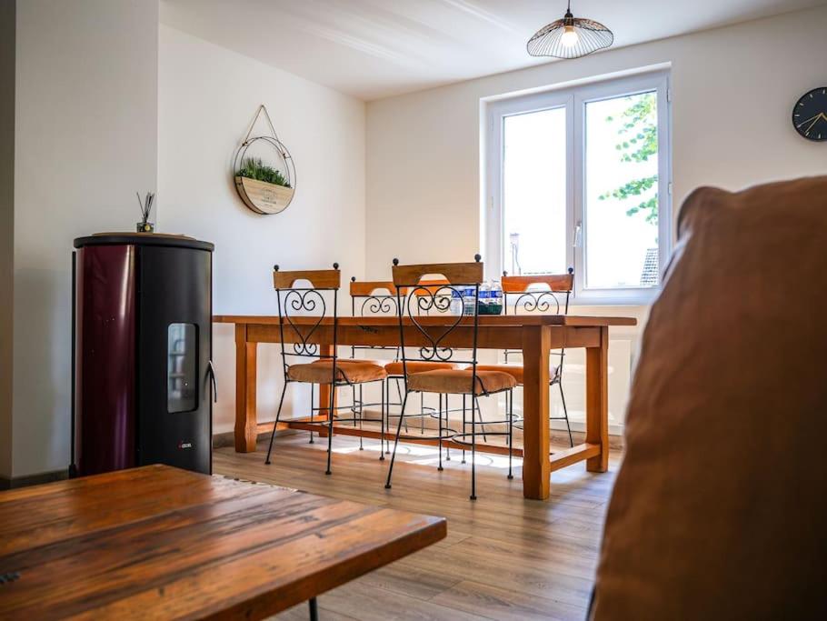 - une salle à manger avec une table et des chaises en bois dans l'établissement Le Convivial • Stationnement Facile • Paisible, à Déols