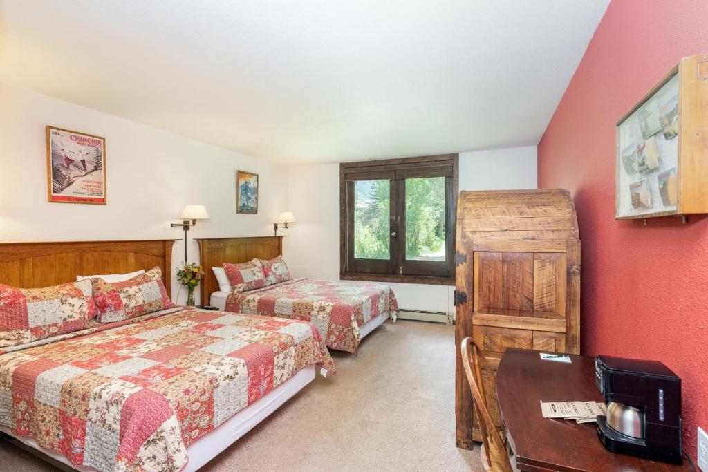 1 dormitorio con 2 camas y mesa. en Manitou Lodge 2 Hotel Room, en Telluride