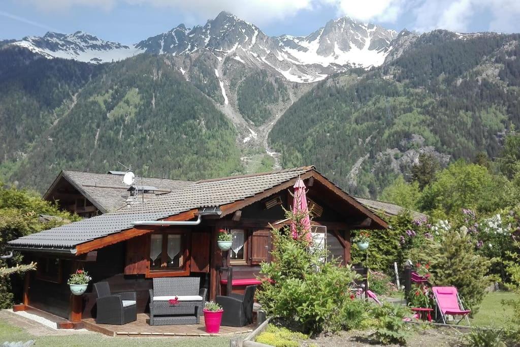 une petite maison avec des montagnes en arrière-plan dans l'établissement Mazot le Petit Drus, à Chamonix-Mont-Blanc