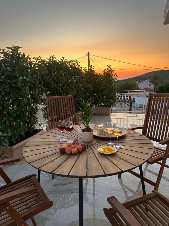 a wooden table with fruit and wine glasses on a patio at Marble's Residence in Argostoli