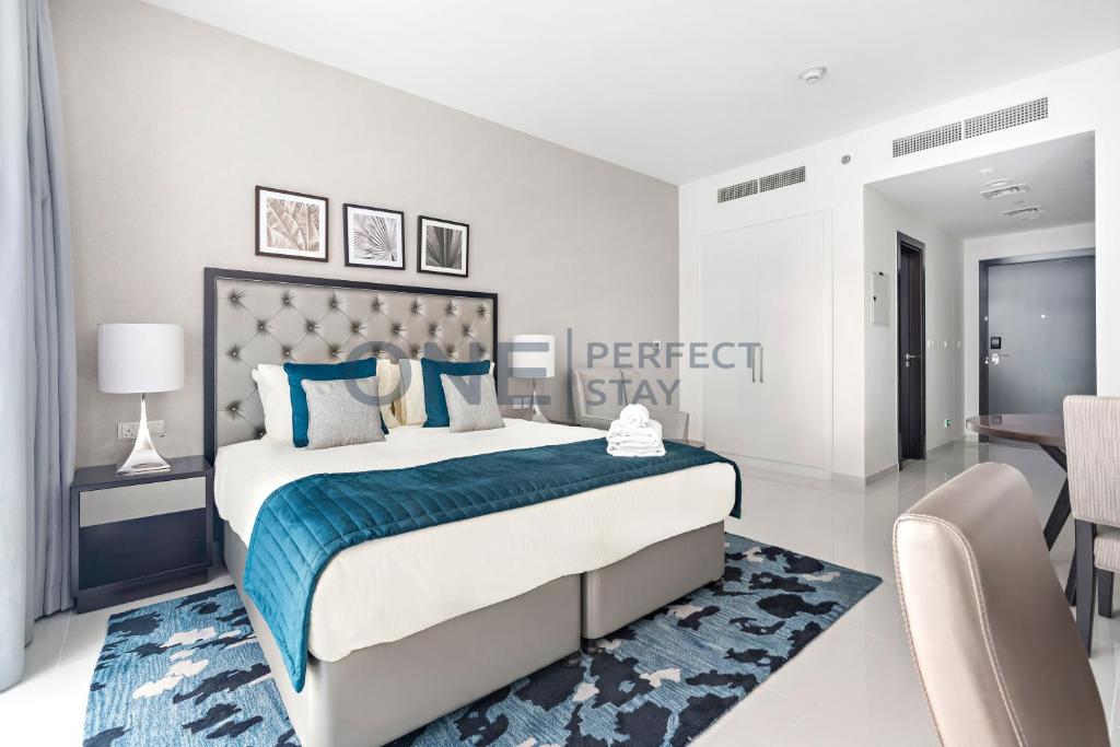 - une chambre dotée d'un grand lit avec des oreillers bleus et blancs dans l'établissement Posh Studio - Comfort and Peace - Bills Included, à Dubaï