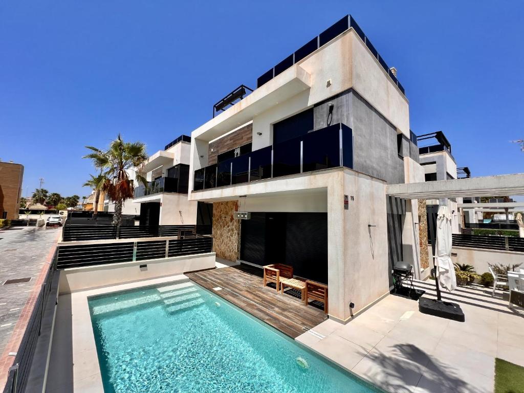 a house with a swimming pool in front of it at Cape villa in Cabo de Roig by Perfectly Rentals in Orihuela
