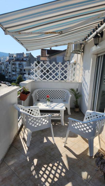 patio con mesa y sillas en el balcón en Altvarg en Igalo