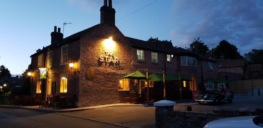 a brick building with tables and chairs in front of it at The Star Inn in North Dalton