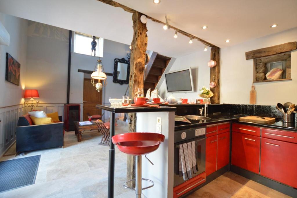 a kitchen with a red stool in the middle at La porcherie du pet en l&#39;air in Saint Malo