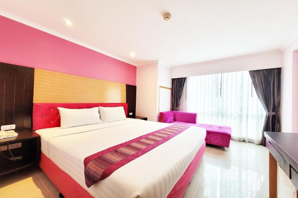 a hotel room with a large bed and a chair at Citin Pratunam Bangkok by Compass Hospitality in Bangkok