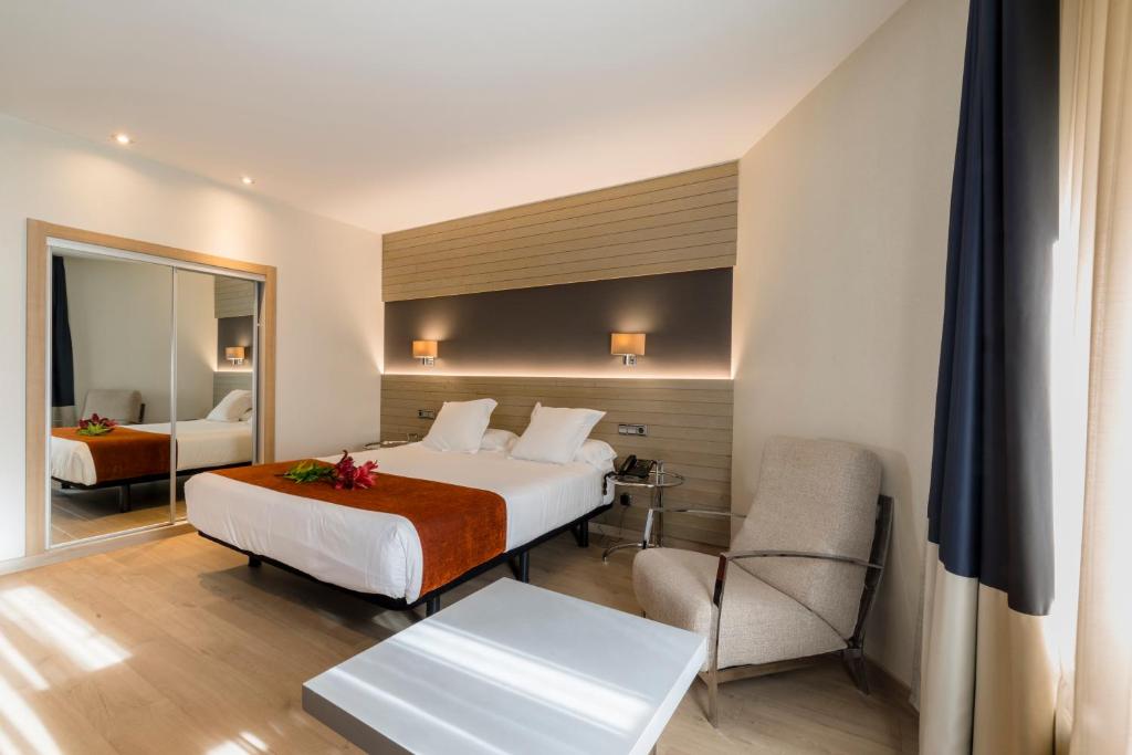 Habitación de hotel con cama y silla en Hotel Avenida, en A Coruña