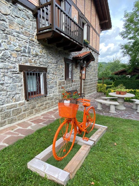 Una bicicleta naranja con una cesta delante de un edificio en TXORIENEA Rural, en Irún