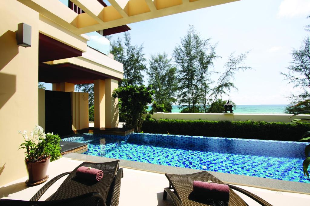 a backyard with a swimming pool and a house at Mövenpick Resort Bangtao Beach Phuket in Bang Tao Beach