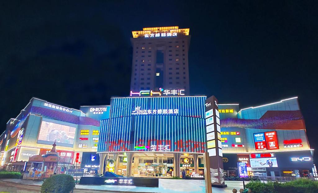 a large building with lights on top of it at night at Zhongshan Phoenix By Funyard in Zhongshan