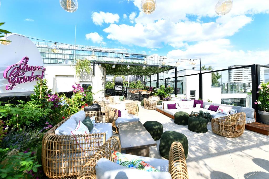 eine Terrasse mit Sofas und Stühlen auf einem Gebäude in der Unterkunft Hotel Zoo Berlin in Berlin