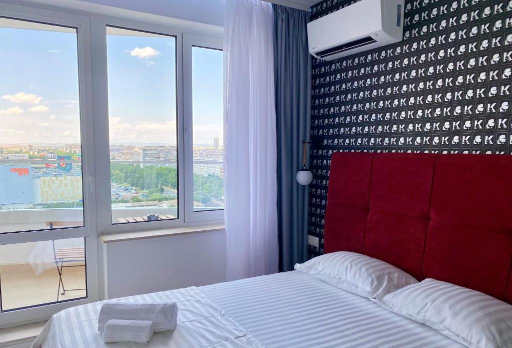 a bedroom with a red headboard and a large window at Arena MALL Galleria View and Securities Parking1 in Burgas City