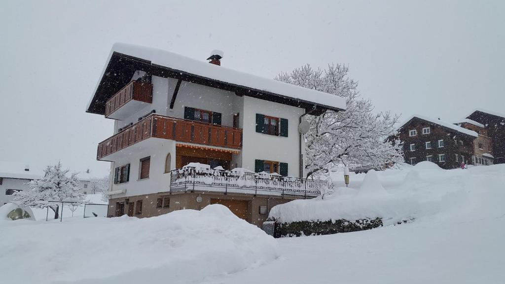een huis bedekt met sneeuw met een berg sneeuw bij Haus Salzmann in Sankt Gallenkirch