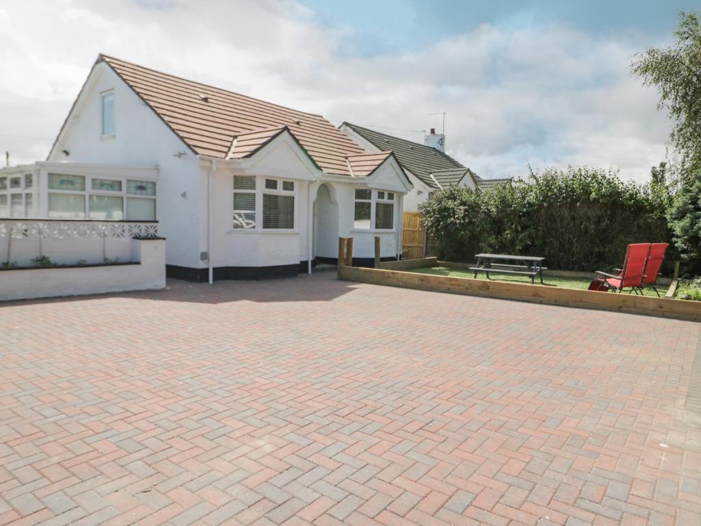 a white house with a brick driveway at Branwen in Talacre