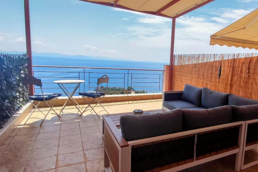 a living room with a couch and a table on a balcony at Simply Meraki Gytheian apt with Panoramic Sea View in Gythio