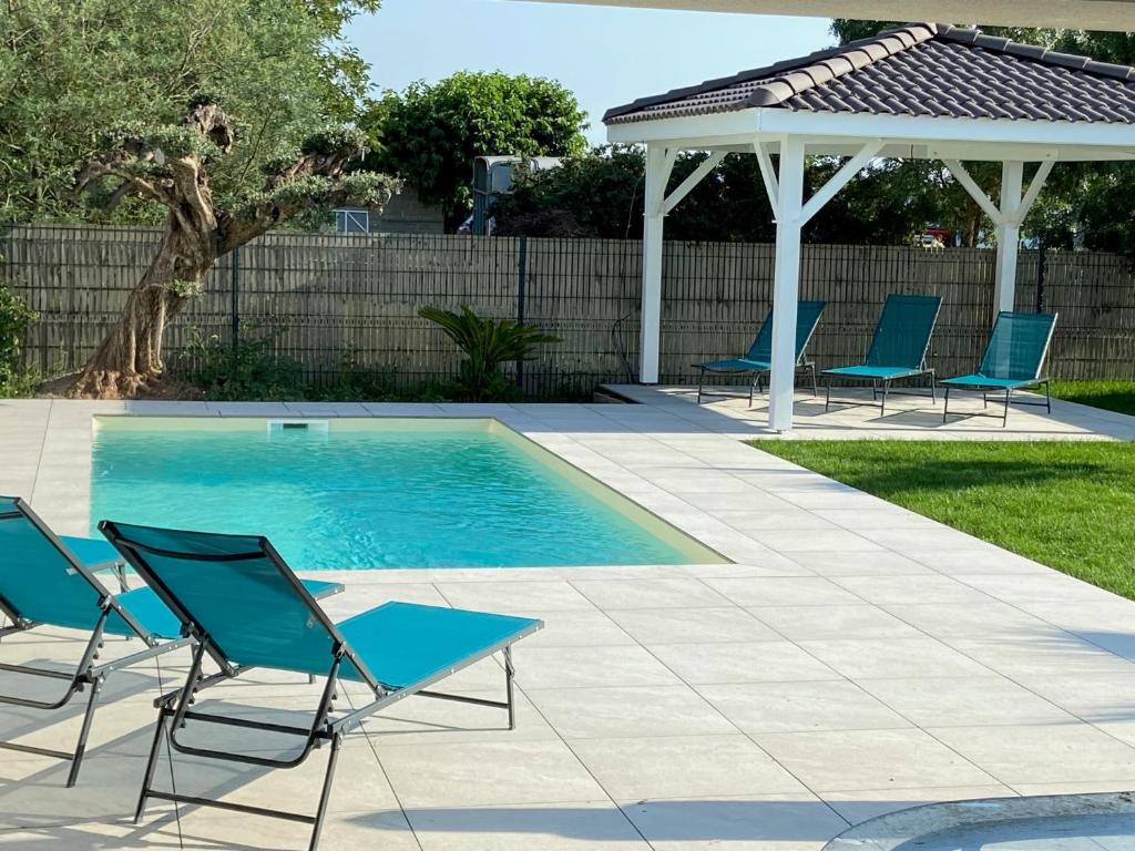 a swimming pool with chairs and a gazebo at Jolie maison proche de Toulouse in Lherm