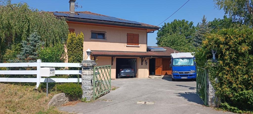 un autobus blu parcheggiato di fronte a una casa di Chez les Michel a Viry