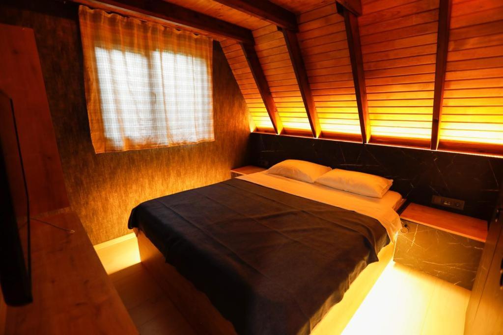 1 dormitorio con 1 cama en una habitación con ventana en Pafuli Bungalov, 