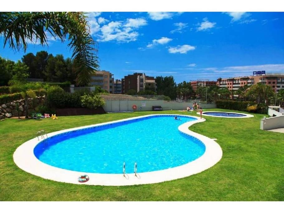a large swimming pool in a grassy field at Magnifico Paradis Village in Salou