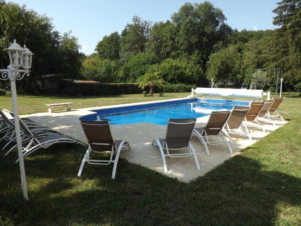 un grupo de sillas sentadas alrededor de una piscina en Le Domaine du Cerf - Gites et nature, en Saint-Ouen-les-Vignes