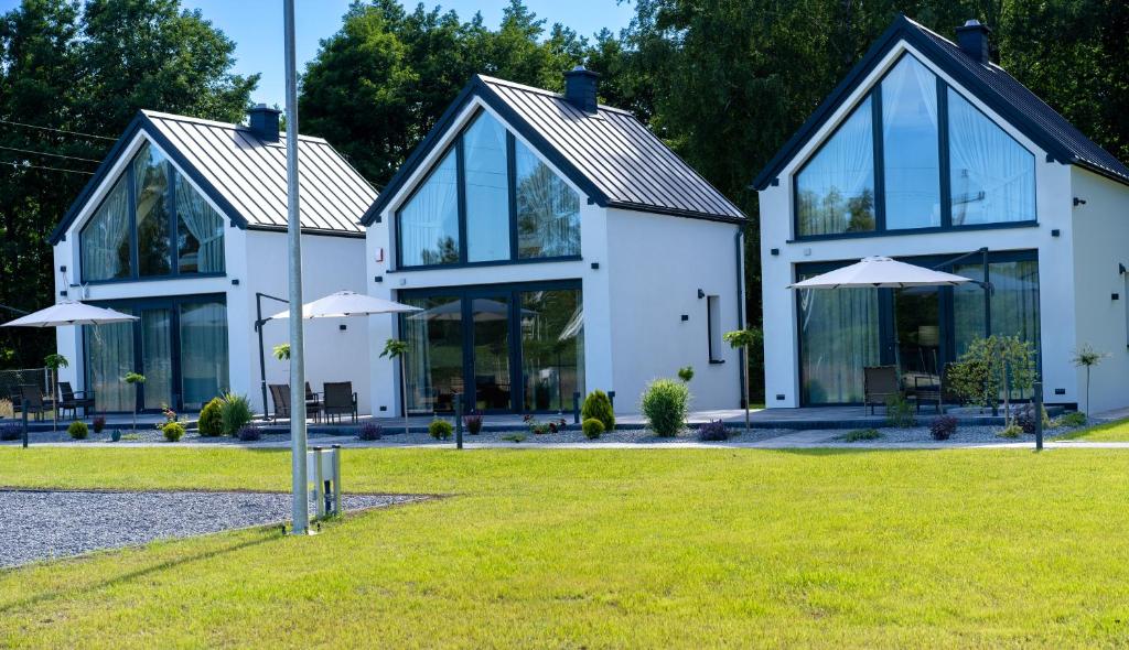 a large white house with glass windows and umbrellas at Bałtyckie Zacisze Kopalino in Kopalino