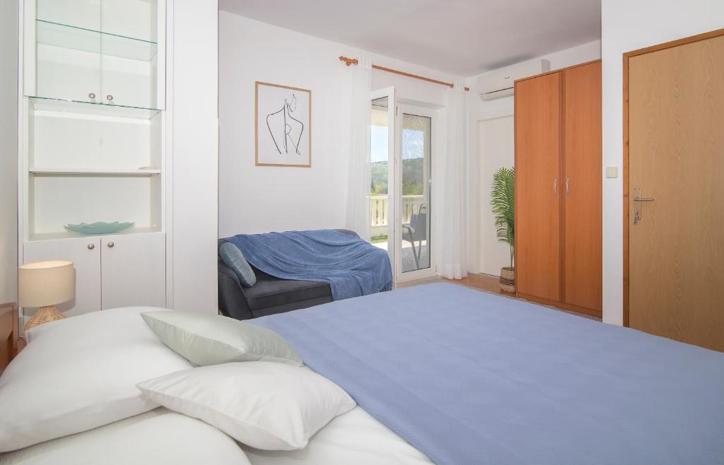 a white bedroom with a large bed and a window at Apartmani Krmek in Mlini