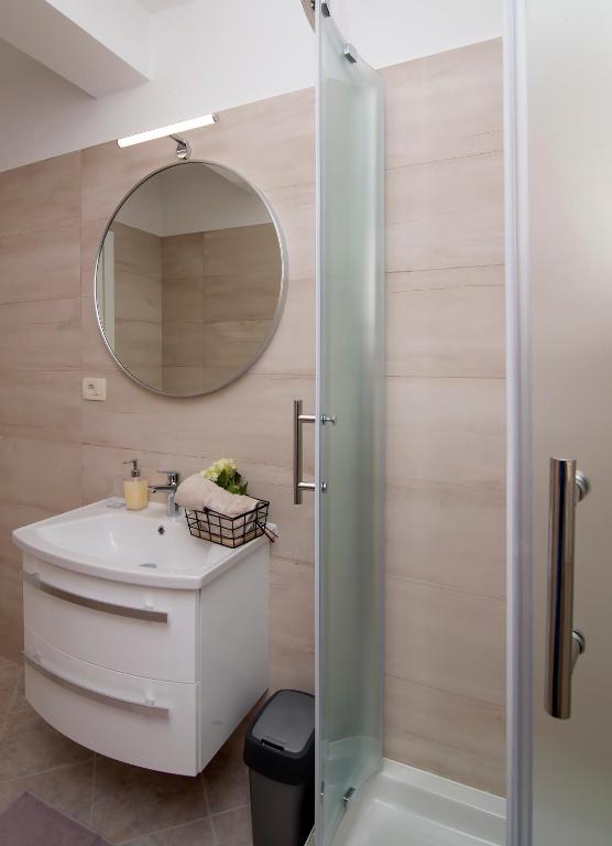 a bathroom with a sink and a mirror at Apartmani Krmek in Mlini