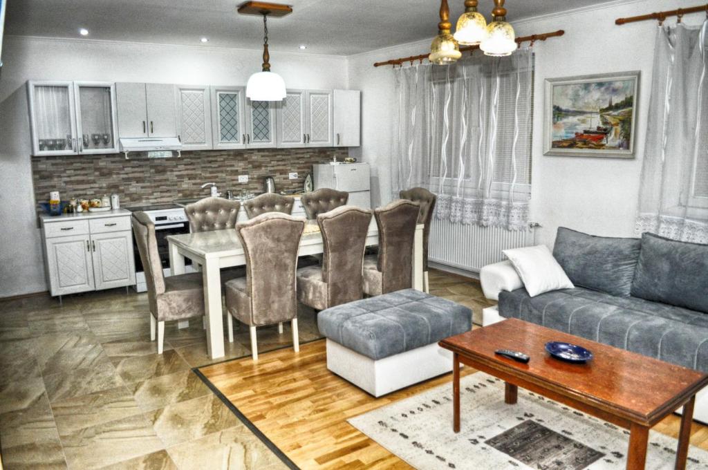 a kitchen and living room with a table and a couch at Zlatna Vila in Kanjiža