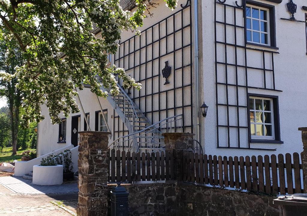 a fence in front of a house with a staircase at Ferienwohnung im Landhausstiel in Winkel
