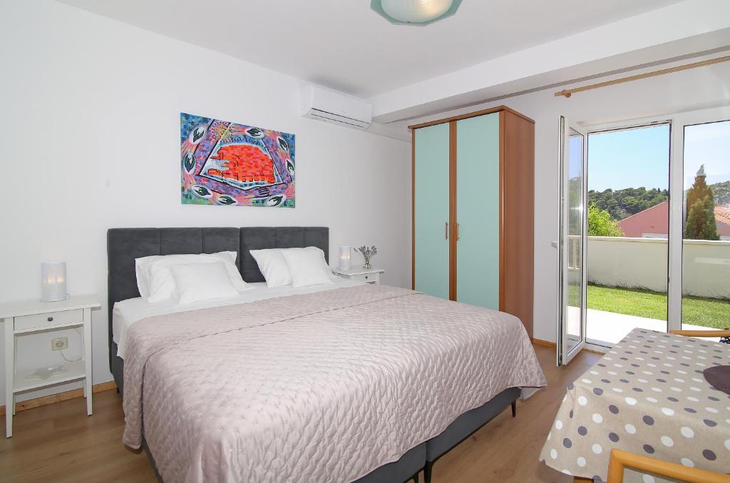 a bedroom with a large bed and a window at Apartmani Krmek in Mlini