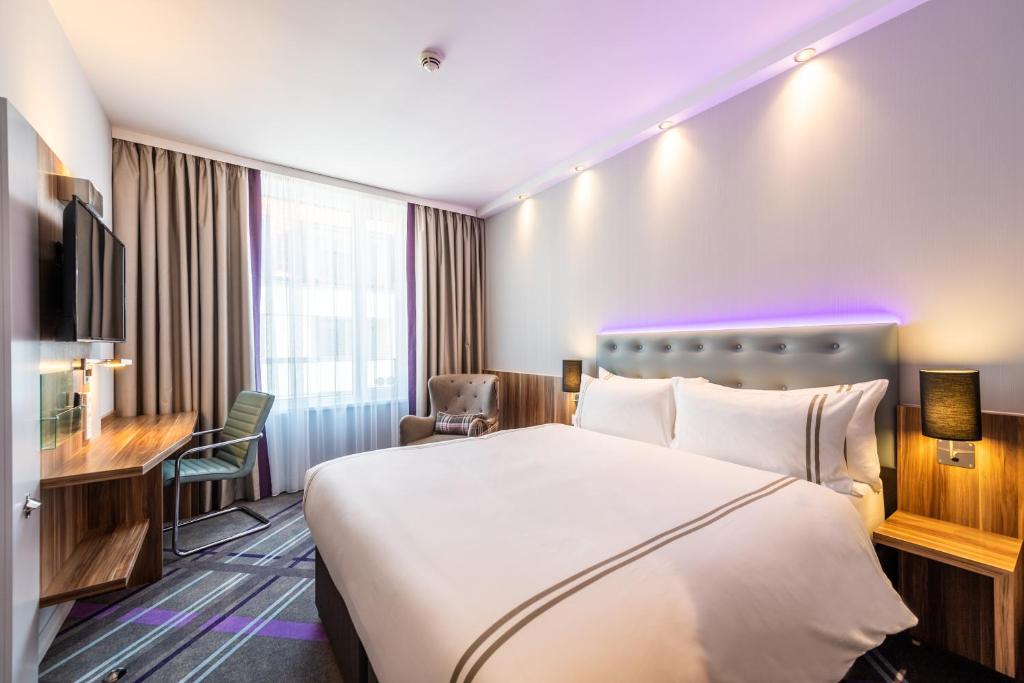 a hotel room with a large bed and a desk at Premier Inn Dresden City Zentrum in Dresden