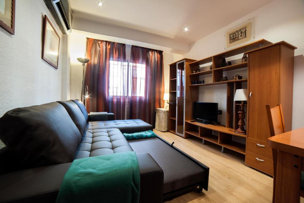 sala de estar con sofá y TV en Apartamento Granados, en Granada