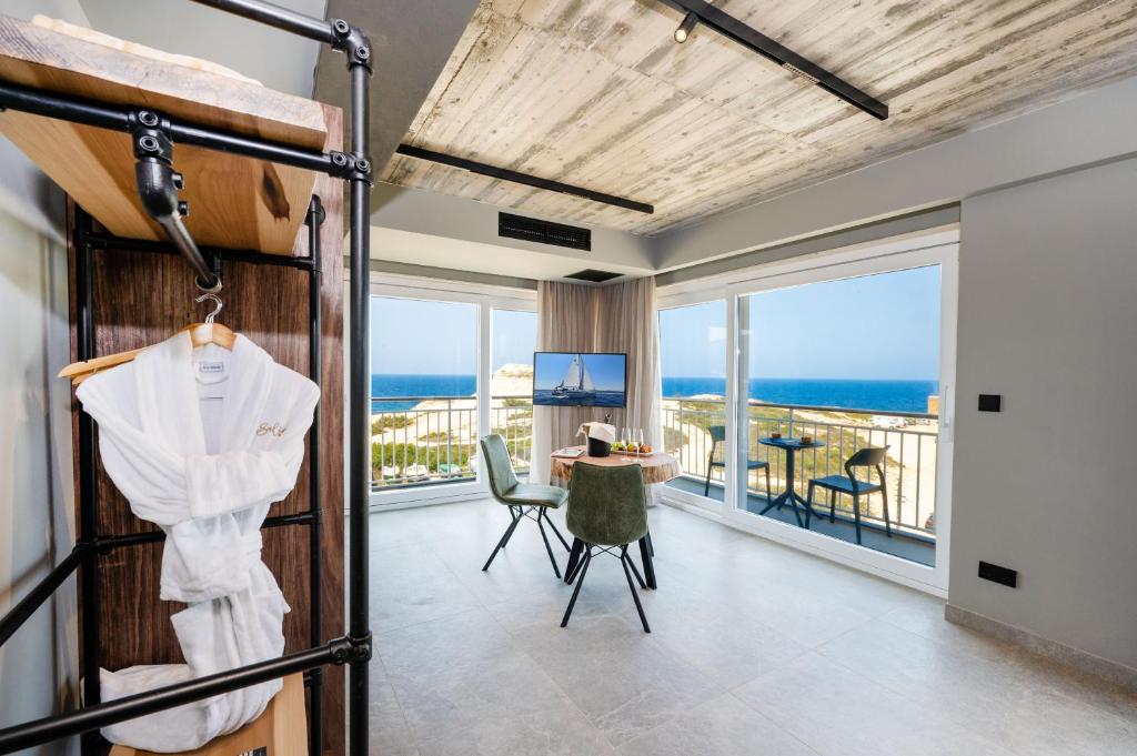 a bedroom with a bed and a view of the ocean at Salini Suites in Żebbuġ