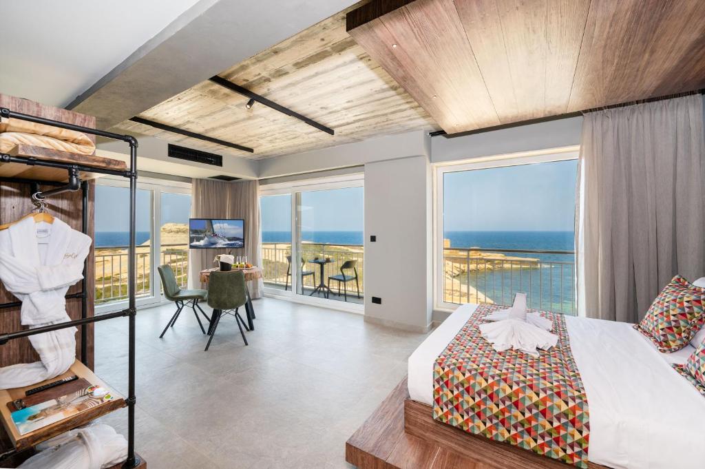 a bedroom with a bed and a view of the ocean at Salini Suites in Żebbuġ