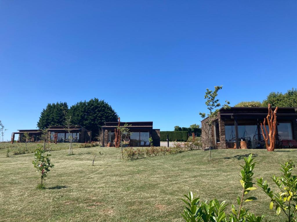 een huis in het midden van een veld bij O REFUXIO DOS CEBREIROS in Mazaricos