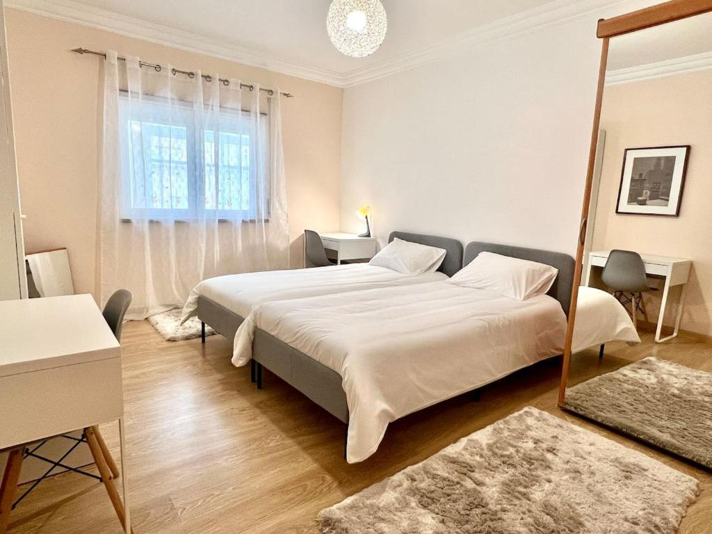 ein Schlafzimmer mit einem großen Bett und einem Spiegel in der Unterkunft Casa Cabo Avelar T4 - Mer in Peniche