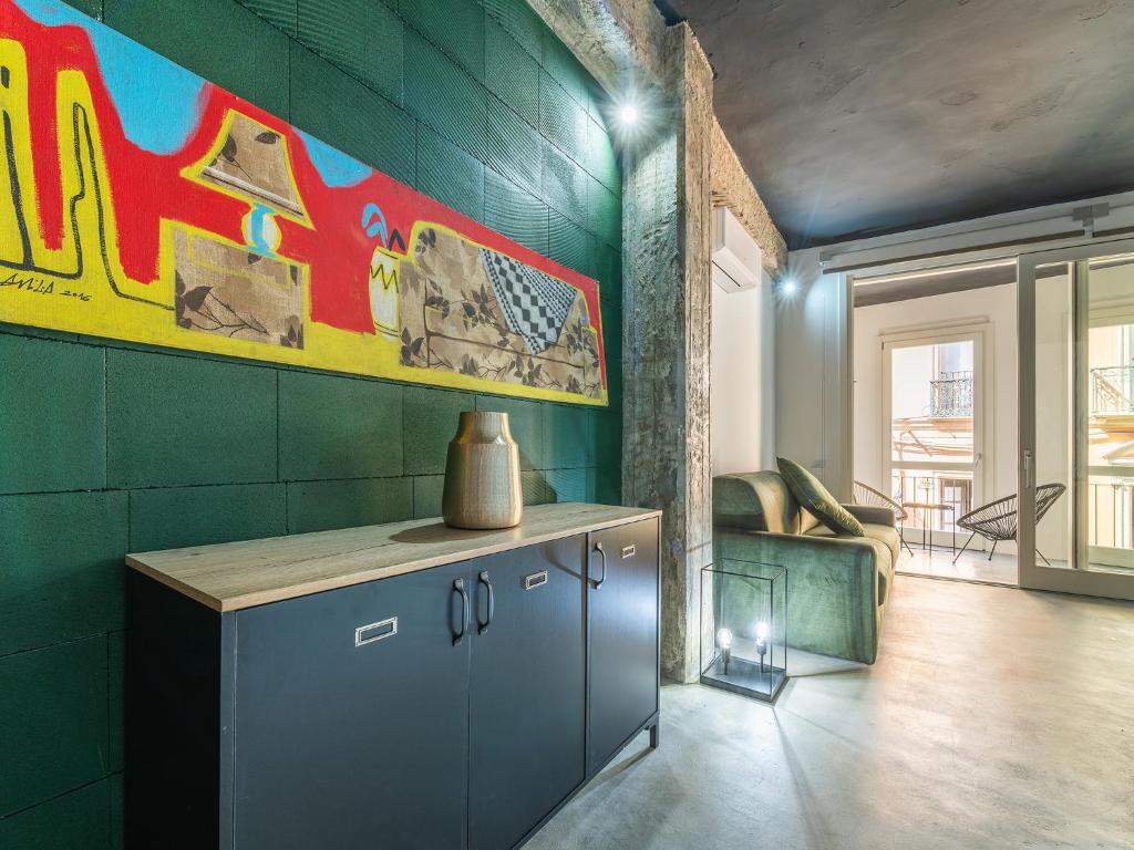 Cette chambre aux murs verts dispose d'une cuisine avec un comptoir. dans l'établissement Ex Magazzini, à Cagliari