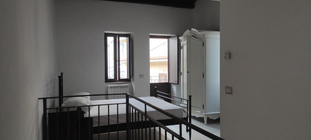 une chambre blanche avec un banc et des fenêtres dans l'établissement casa vacanza caffe', à Roccavaldina