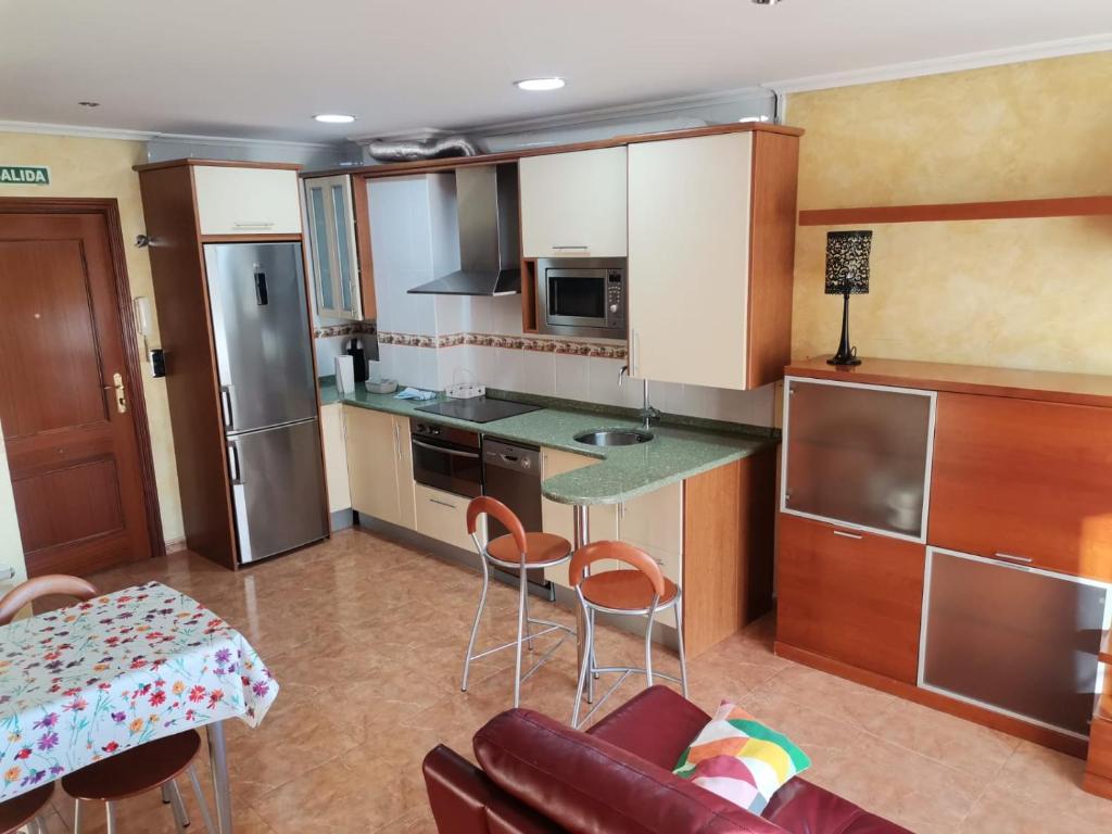 une cuisine avec un comptoir, une table et des chaises dans l'établissement apartamento Puente, à Suances