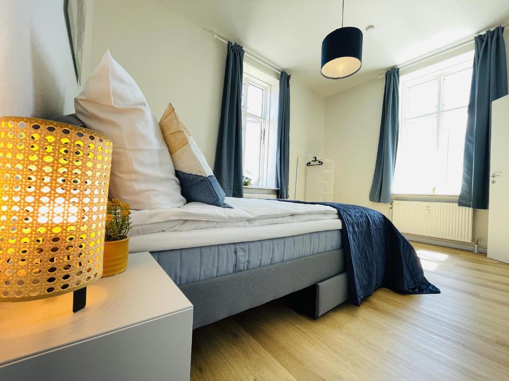 En eller flere senge i et værelse på aday - Blue light suite apartment in the center of Hjorring