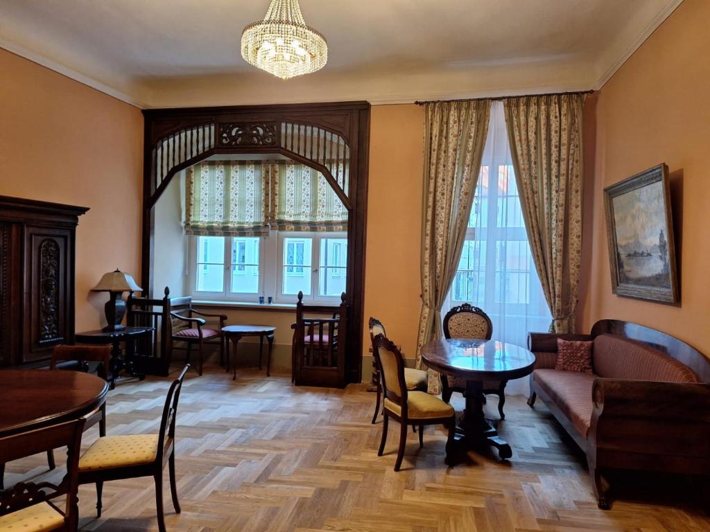 a living room with a couch and a table and chairs at Stadtpalais Marché-Suite maximal 2 Personen und 1 Kleinkind in Bautzen