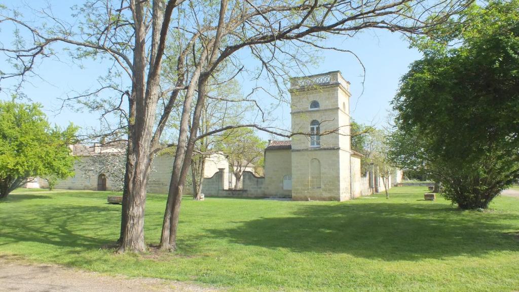 um edifício com uma torre no meio de um campo em La Tour du Domaine de Choisy em Abzac