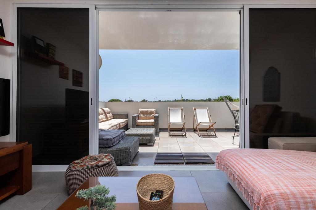 a bedroom with a view of a living room at Santa Luzia Green Apartment in Santa Luzia